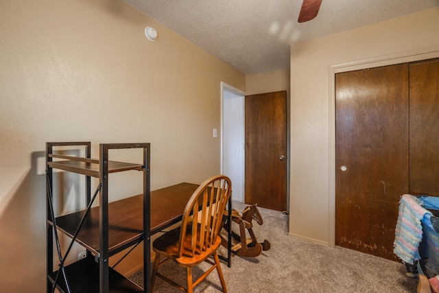 dining space featuring ceiling fan, a textured ceiling, and light colored carpet