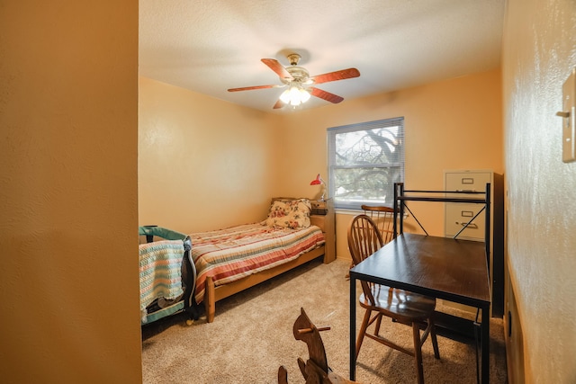 bedroom with ceiling fan, carpet flooring, and a textured wall