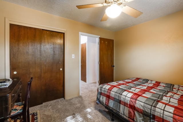 carpeted bedroom with a textured ceiling, a closet, and a ceiling fan