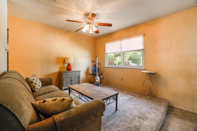 living area with carpet floors, ceiling fan, baseboards, and a textured ceiling