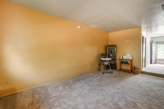 unfurnished office with a textured ceiling, carpet, and visible vents