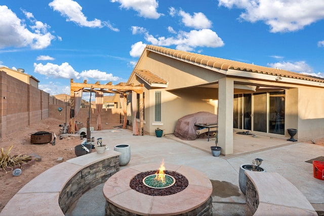 view of patio with a fenced backyard, a grill, a fire pit, and a pergola