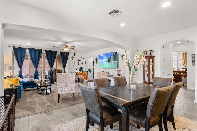 dining area featuring arched walkways, ceiling fan, recessed lighting, visible vents, and light wood-style floors