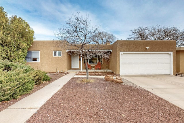 southwest-style home with a garage, driveway, and stucco siding