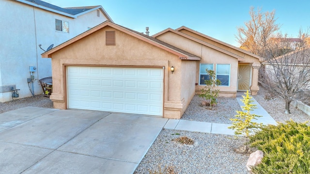 single story home featuring a garage, driveway, and stucco siding