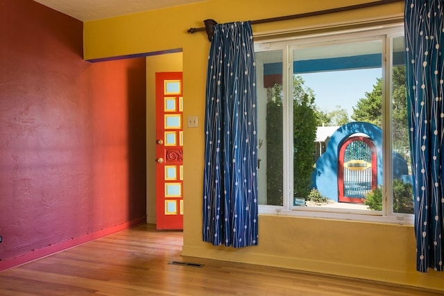 interior space with wood finished floors, visible vents, and baseboards