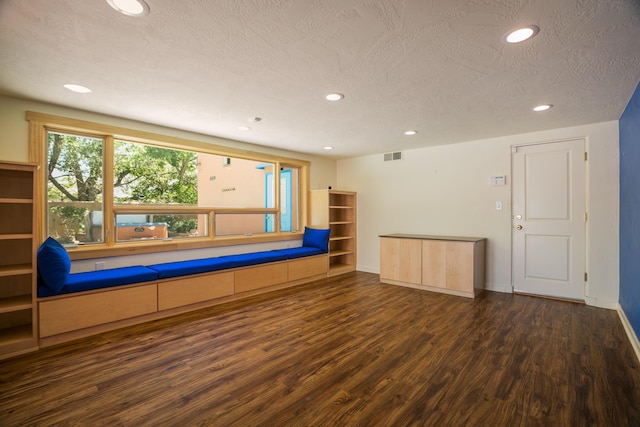 interior space with a textured ceiling, wood finished floors, visible vents, and recessed lighting