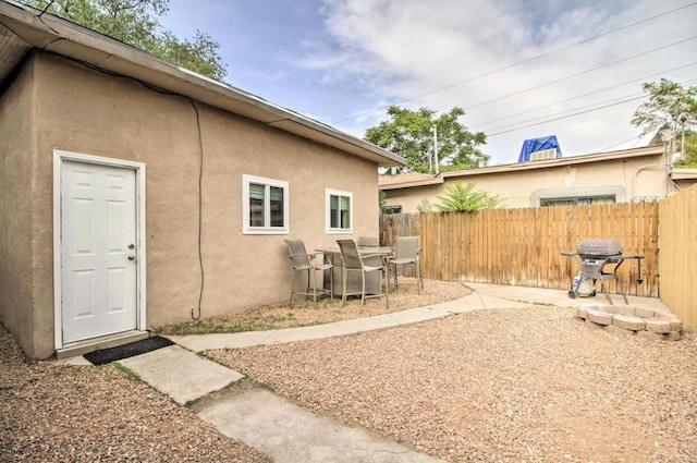 back of house with a patio area, fence, and stucco siding