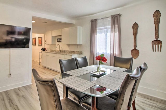 dining space with light wood finished floors and baseboards