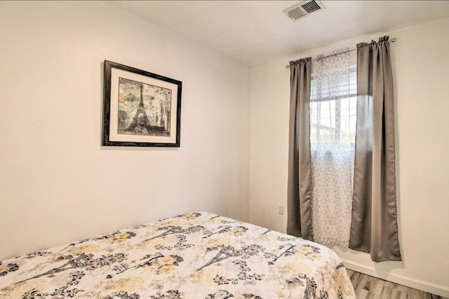 unfurnished bedroom with visible vents and wood finished floors