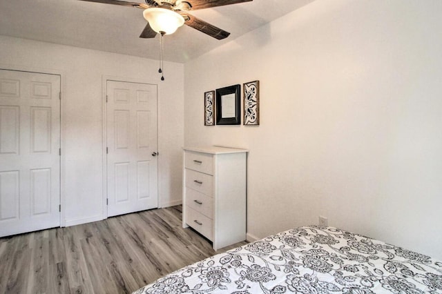 bedroom featuring light wood finished floors, a ceiling fan, and baseboards