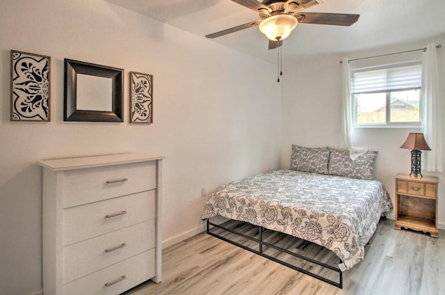 bedroom with ceiling fan, light wood finished floors, and baseboards