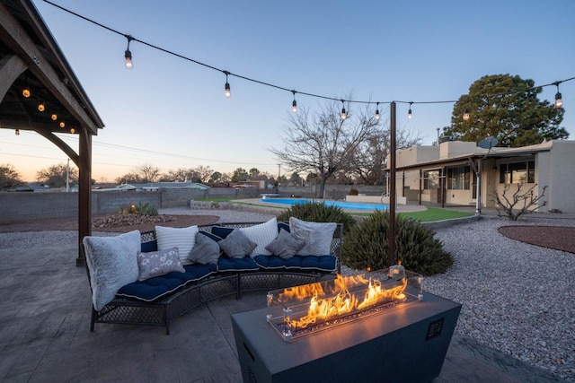 view of patio with fence, an outdoor pool, and a fire pit