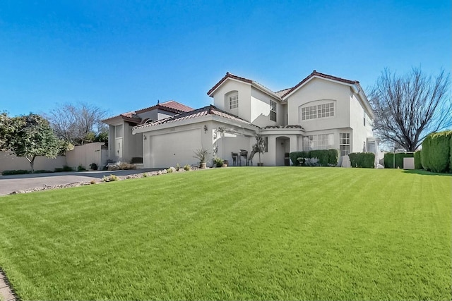 mediterranean / spanish-style home featuring a tile roof, stucco siding, an attached garage, a front yard, and driveway