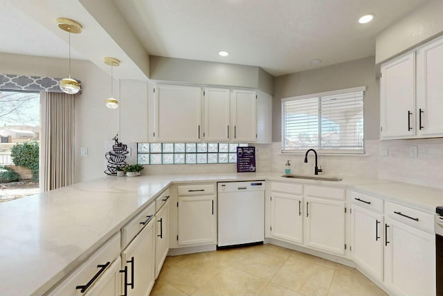 kitchen featuring white cabinetry, white dishwasher, backsplash, and a sink