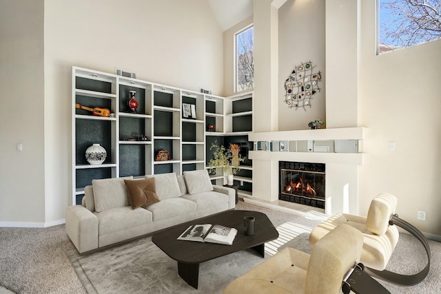 living area featuring carpet floors, a fireplace, high vaulted ceiling, and baseboards