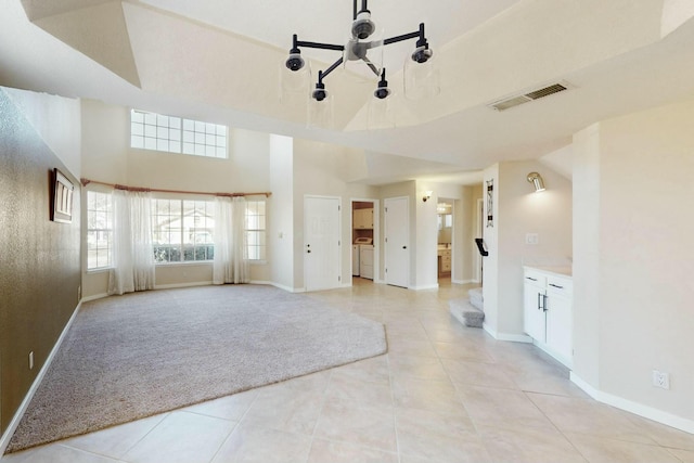 unfurnished living room featuring stairs, light colored carpet, visible vents, and light tile patterned flooring