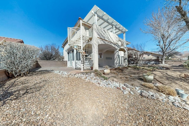 view of front of house with fence, stairway, and a patio