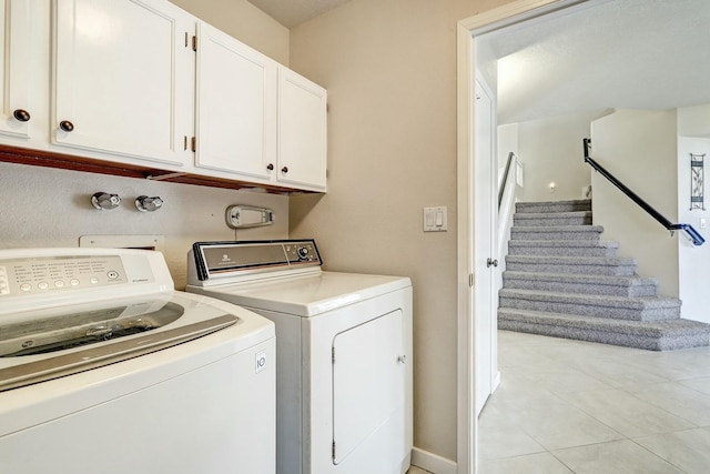 laundry room featuring light tile patterned flooring, washing machine and clothes dryer, and cabinet space