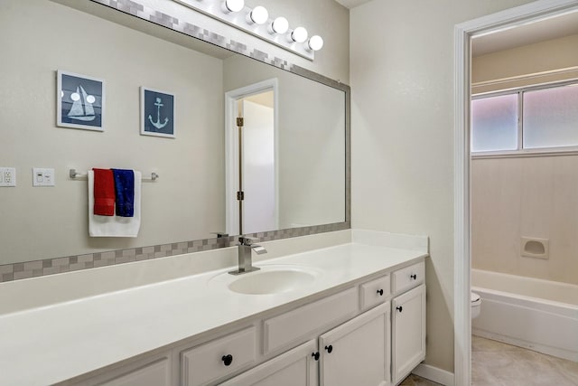 bathroom featuring toilet, tile patterned floors, a bath, and vanity