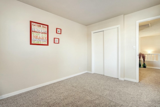 unfurnished bedroom featuring carpet, a closet, visible vents, and baseboards