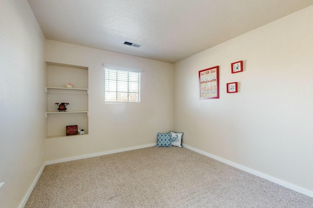 carpeted empty room featuring a textured ceiling, visible vents, and baseboards