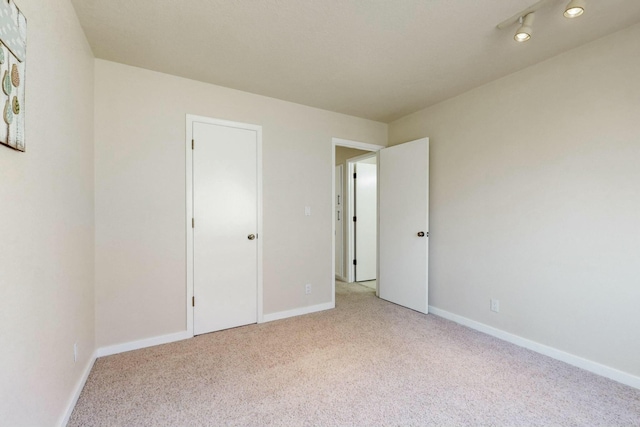 unfurnished bedroom with light carpet and baseboards