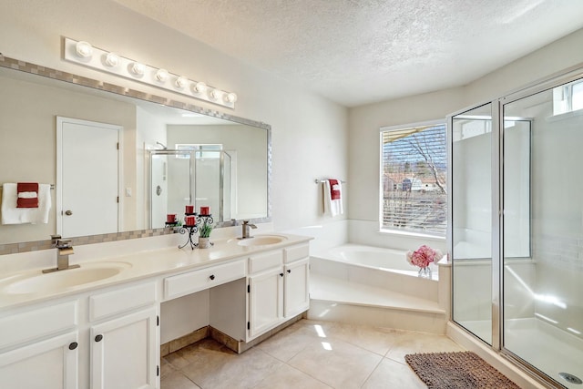 bathroom with a stall shower, tile patterned flooring, a garden tub, and a sink