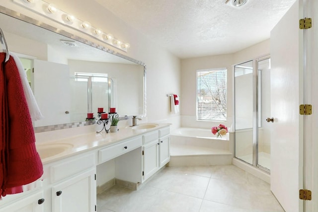 full bath featuring a garden tub, double vanity, a stall shower, a textured ceiling, and tile patterned floors