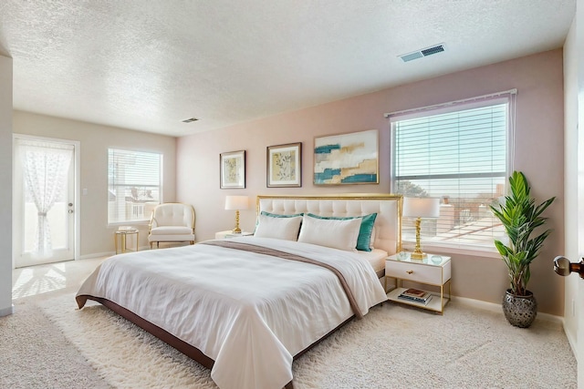 bedroom featuring carpet, visible vents, a textured ceiling, and baseboards