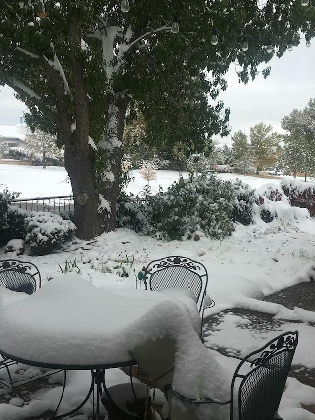 yard layered in snow featuring fence