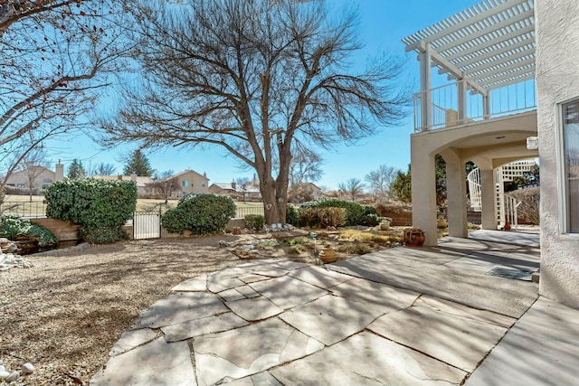 view of patio with fence, a gate, and a pergola