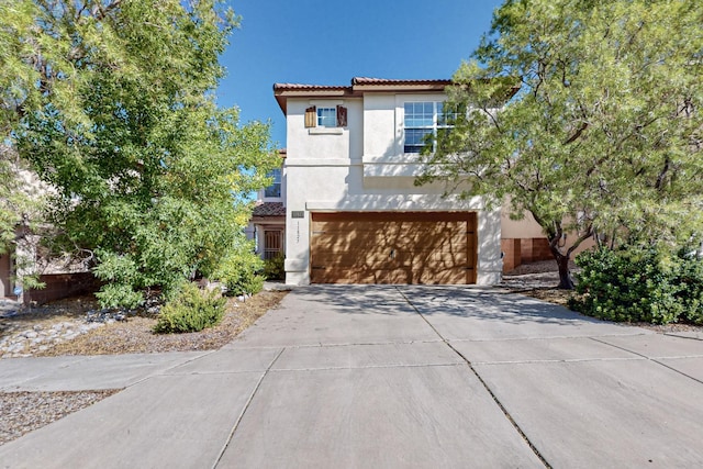 view of front of house featuring stucco siding, concrete driveway, an attached garage, fence, and a tiled roof