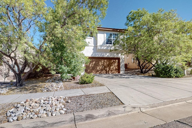 view of front of house featuring a garage, driveway, and stucco siding