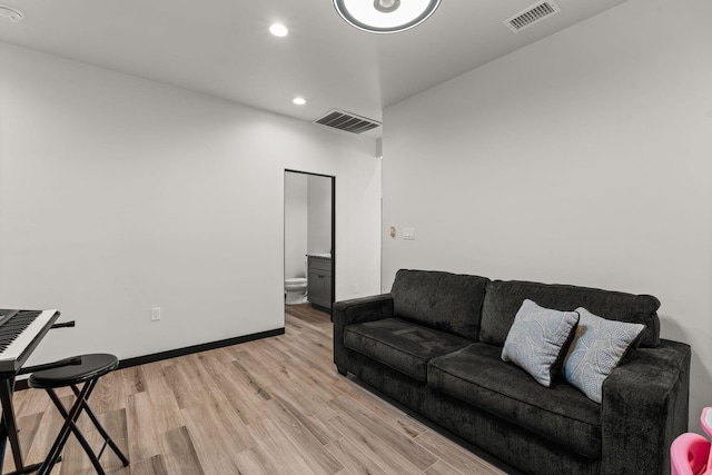 living room with recessed lighting, visible vents, light wood-style flooring, and baseboards