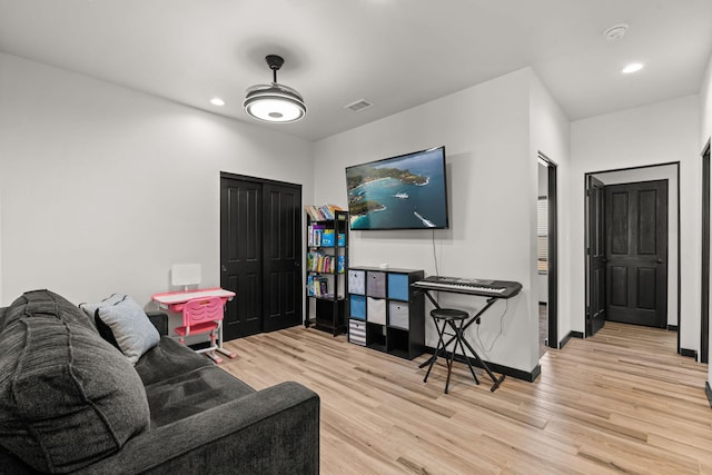 living area featuring recessed lighting, visible vents, baseboards, and wood finished floors