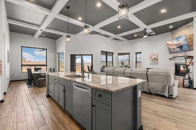 kitchen with light wood-type flooring, gray cabinets, dishwasher, and a sink