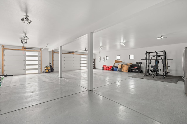 garage with a garage door opener and freestanding refrigerator