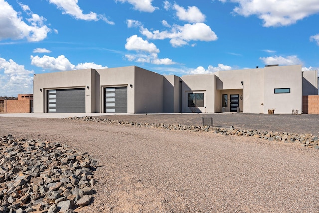 adobe home with an attached garage and stucco siding