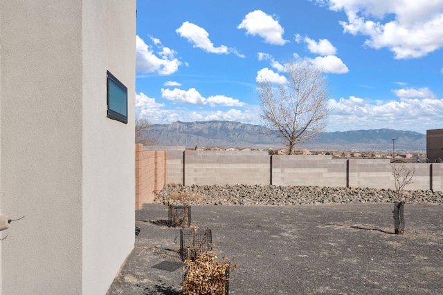 view of yard with a fenced backyard and a mountain view