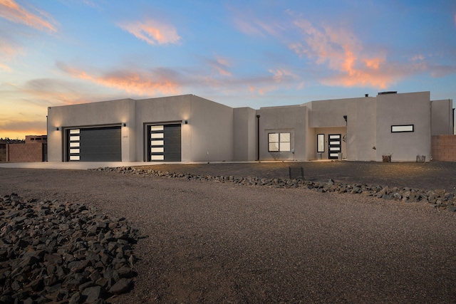 southwest-style home featuring a garage, driveway, and stucco siding