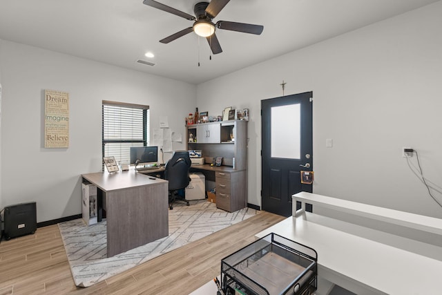 home office with visible vents, a ceiling fan, light wood-style flooring, and baseboards