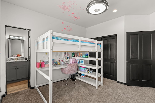 bedroom featuring carpet floors, ensuite bath, and baseboards