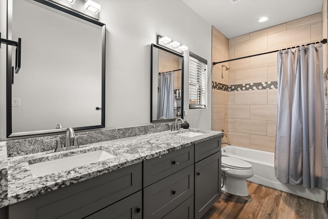 full bath featuring toilet, wood finished floors, a sink, and shower / bath combo with shower curtain