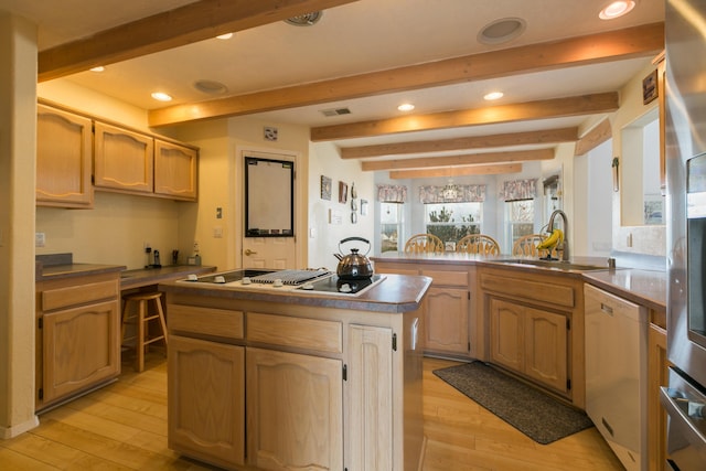 kitchen with light wood finished floors, white appliances, dark countertops, and a sink