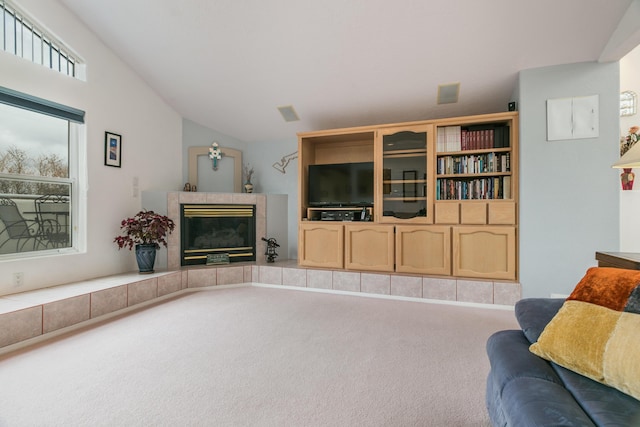 living area with lofted ceiling, carpet flooring, and a fireplace