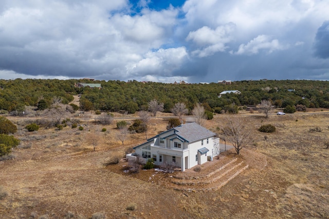 birds eye view of property featuring a wooded view