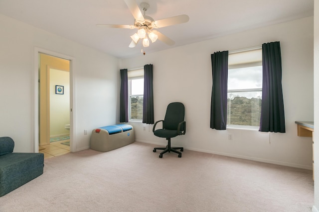 living area featuring baseboards, carpet floors, and a ceiling fan