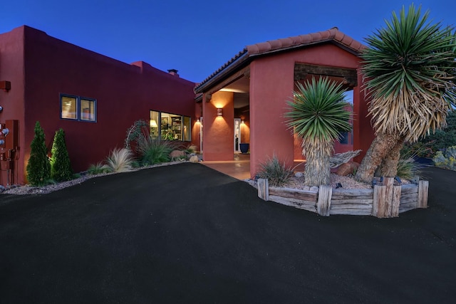 view of front of house featuring driveway and a tiled roof