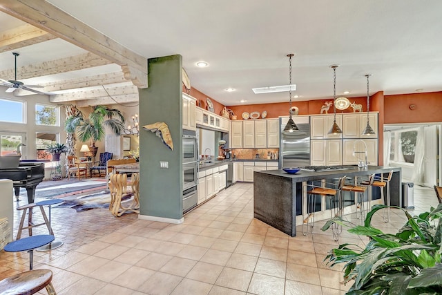 kitchen featuring light tile patterned floors, dark countertops, appliances with stainless steel finishes, and ceiling fan